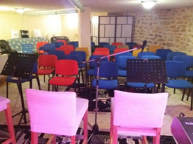 La salle de cours de l’école : chaises colorées et pupitres à musique.