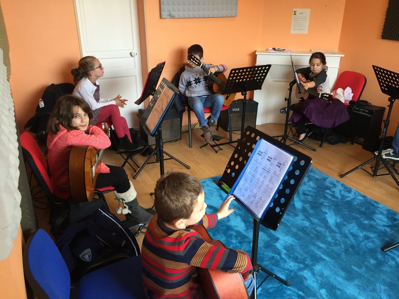 Cours collectif : des enfants suivent la partition affichée sur tablette.