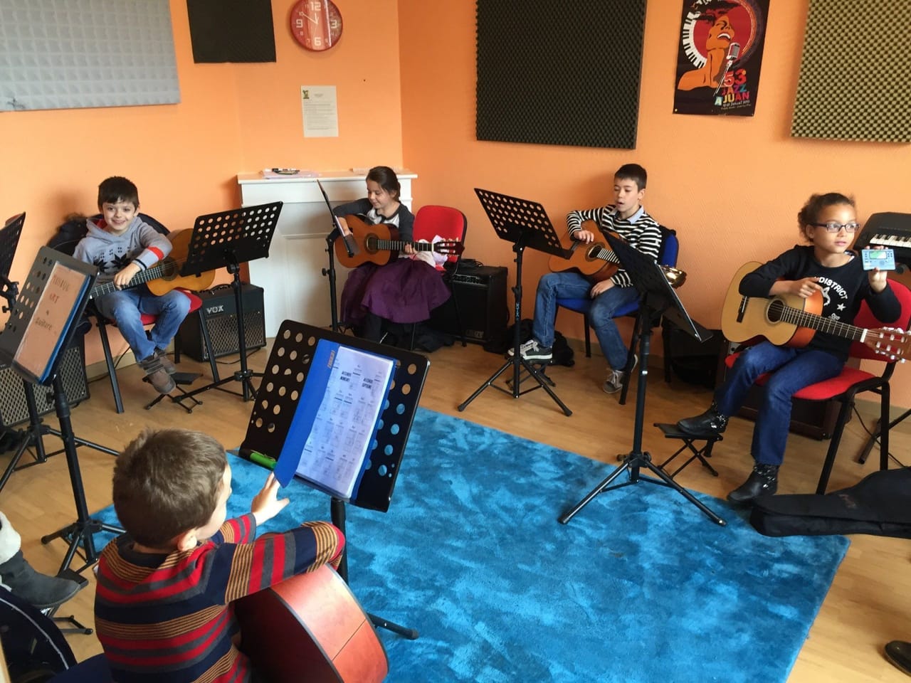 Atelier de guitare en groupe dans la salle orange de l’école.