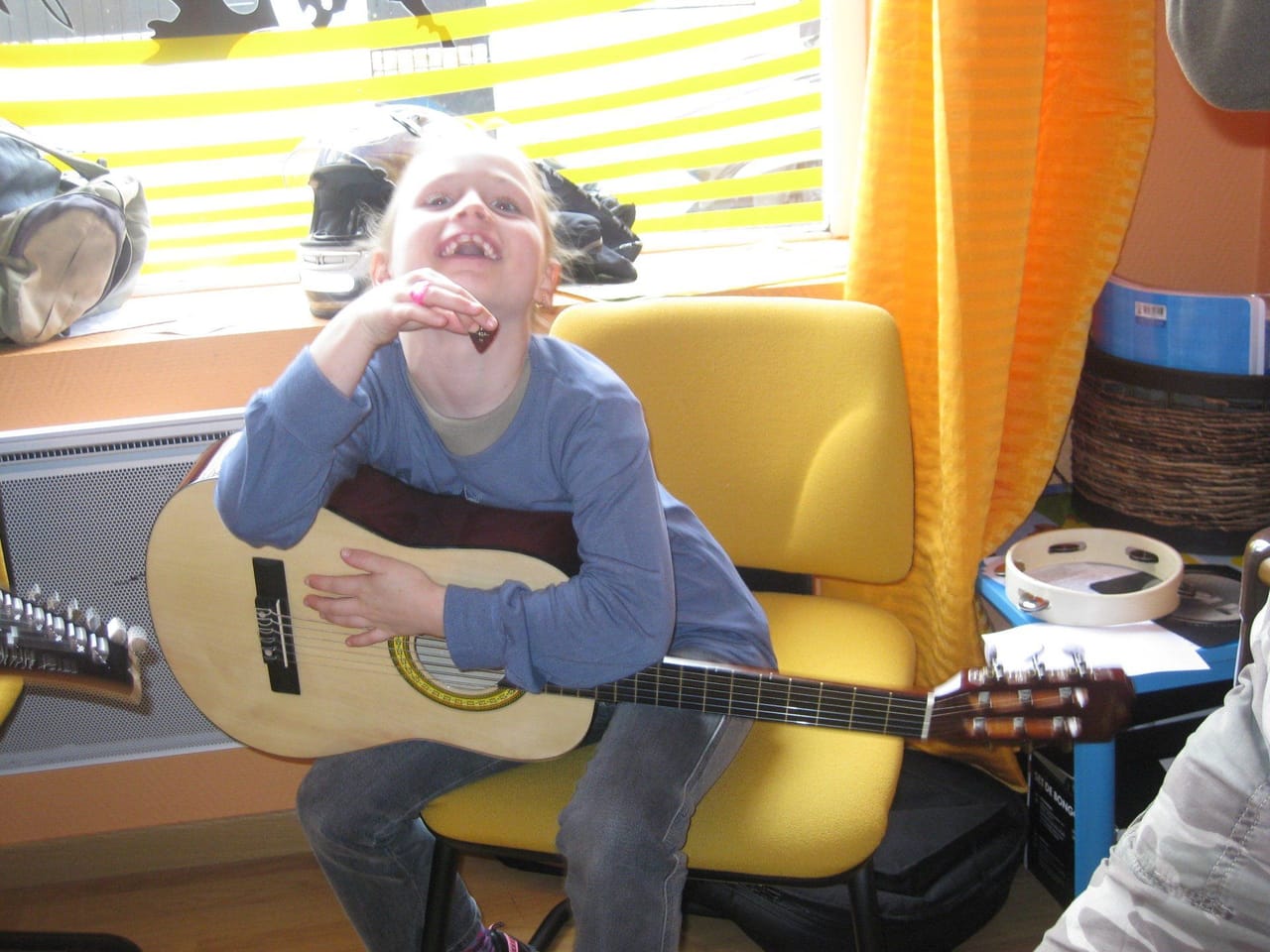 Un enfant chante en tenant une guitare acoustique.