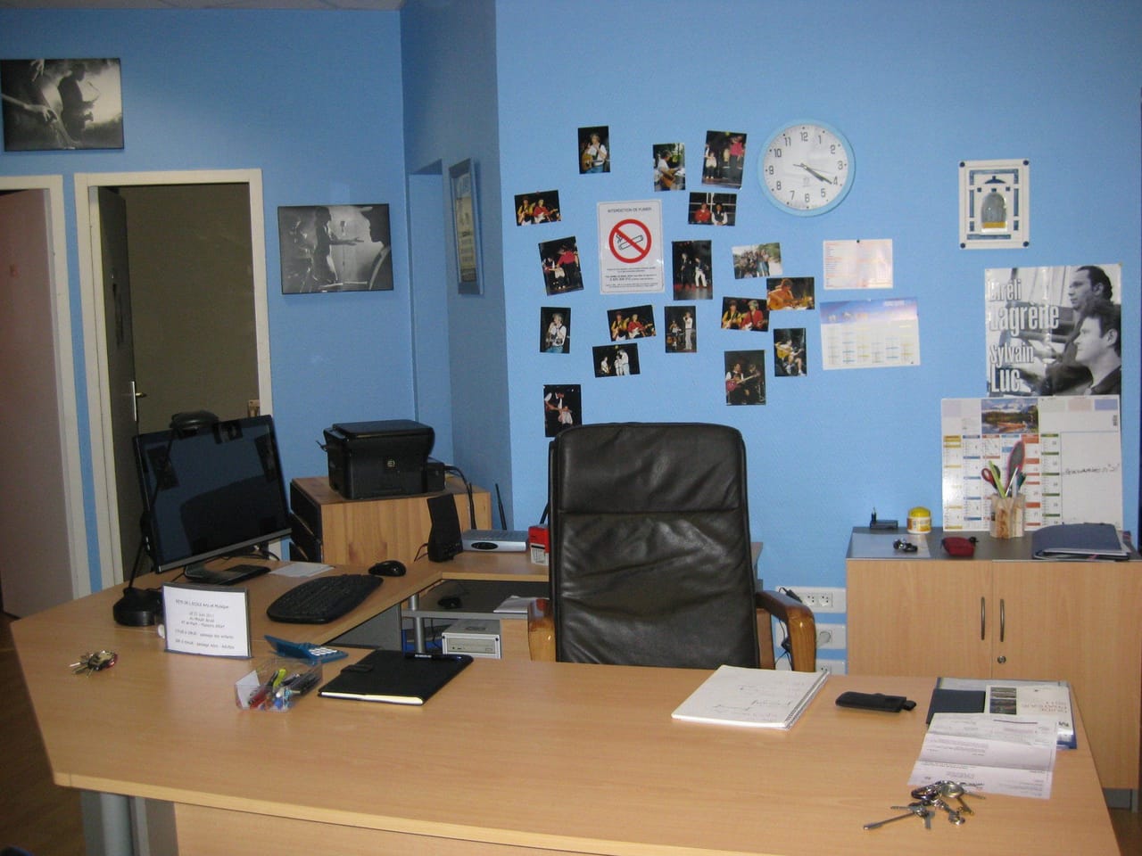 Un coin de l’école : mur de photos et fauteuil.