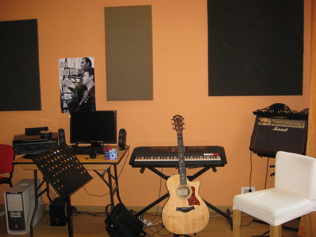 Salle de répétition : claviers, guitare et panneaux acoustiques.